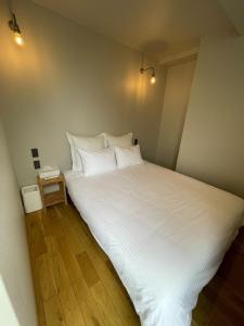 a bedroom with a large bed with white sheets and pillows at YUZUKI - Vacation STAY 92921v in Takamatsu