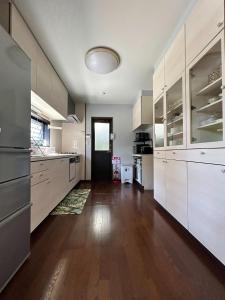 Il comprend une grande cuisine avec des placards blancs et du parquet. dans l'établissement BlueFlow KATSUURA - Vacation STAY 92659v, à Katsuura