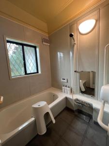 une salle de bain avec baignoire et toilettes et une fenêtre dans l'établissement BlueFlow KATSUURA - Vacation STAY 92659v, à Katsuura
