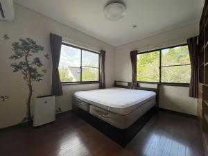 une chambre avec un lit et deux fenêtres dans l'établissement BlueFlow KATSUURA - Vacation STAY 92659v, à Katsuura