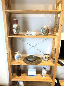 ein Holzregal mit Vasen und Schalen darauf in der Unterkunft Maison Etoile Room 705 - Vacation STAY 14807 in Nagoya