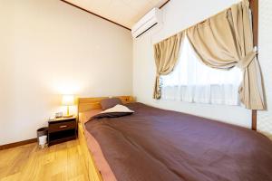 ein Schlafzimmer mit einem großen Bett und einem Fenster in der Unterkunft CoCoSakura - Vacation STAY 94917v in Miyanoshita