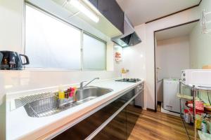 eine Küche mit Spüle und Fenster in der Unterkunft CoCoSakura - Vacation STAY 94917v in Miyanoshita