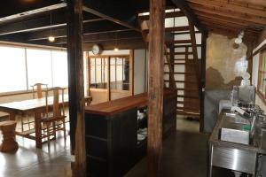 a kitchen and dining room with a desk and a table at Womb Guesthouse Kojima -Uminomieru ie- - Vacation STAY 95107v in Tamano +7 photos