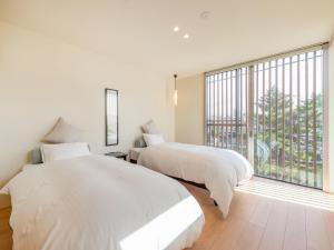 two beds in a bedroom with a large window at ZIPANG - Vacation STAY 20291v in Matsue