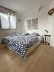 a bedroom with a bed with a blue and white comforter at Villa "La Tourelle" avec piscine privée in Haguenau +15 photos