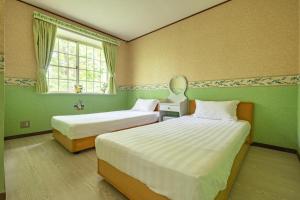 two beds in a room with green walls and a window at Mori no Komei campsite - Vacation STAY 04382v in Kita-karuizawa