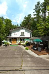 a white house with a porch and a patio at Mori no Komei campsite - Vacation STAY 04382v in Kita-karuizawa