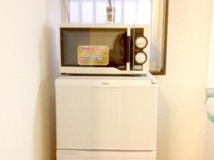 a microwave sitting on top of a white refrigerator at GuestHouse FUKUTOMI - Vacation STAY 95755v in Makishimachi