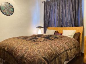 a bedroom with a large bed with a blue curtain at Villa Ashitani - Vacation STAY 08864v in Nantan city +7 photos