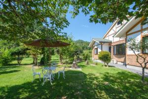 a table and chairs with an umbrella in a yard at Villa Ashitani - Vacation STAY 08864v in Nantan city