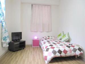 a bedroom with a bed and a tv in it at GuestHouse FUKUTOMI - Vacation STAY 95753v in Makishimachi