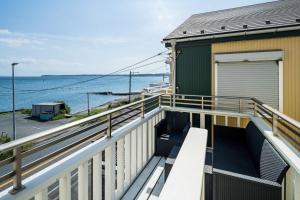 a balcony with a bench overlooking the water at Oceanfront Villa Hale Kahakai - Vacation STAY 52334v in Miura