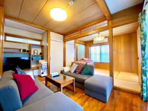 a living room with two couches and a tv at Umino House Nagisa - Vacation STAY 95985v in Nanjo
