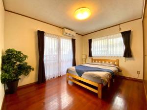 a bedroom with a bed and a large window at Umino House Nagisa - Vacation STAY 95985v in Nanjo