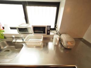 a kitchen counter with a sink and a microwave at Umino House Nagisa - Vacation STAY 95985v in Nanjo +33 photos