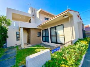 a large white house with a yard at Umino House Nagisa - Vacation STAY 95985v in Nanjo