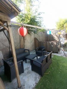 a patio with black couches and a umbrella and a lantern at Nedokoro Minamihama Kujukuri - Vacation STAY 98351v in Kujukuri +7 photos