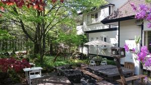 a backyard with a wooden picnic table and chairs at Karuizawa Villa Etoile - Vacation STAY 15095 in Kita-karuizawa