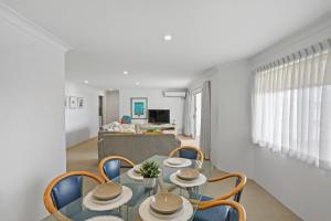 een eetkamer met een glazen tafel en stoelen bij Le Beach Apartments in Gold Coast
