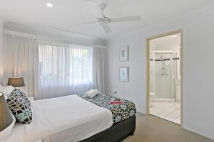 een witte slaapkamer met een bed en een badkamer bij Le Beach Apartments in Gold Coast +24 foto's