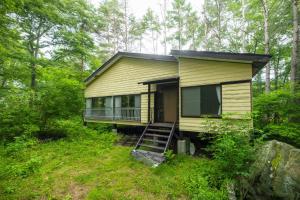 ein gelbes Haus mitten im Wald in der Unterkunft Mori no Komei campsite - Vacation STAY 04454v in Tsumagoi