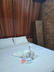 a bed with a towel and a stuffed animal on it at Soluta Resort in Wainapal +17 photos
