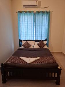 a bed in a room with a blue window at Silver Sand Resorts With Private Swimming Pool in Chennai +25 photos