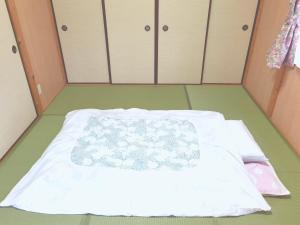 a bed in a room with green floors and cabinets at Garden view Japanese style room - Vacation STAY 15090 in Mimasaka