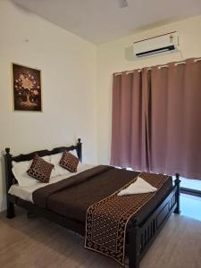 een slaapkamer met een bed en een raam met gordijnen bij Silver Sand resorts With Swimming Pool in Chennai