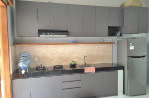 a kitchen with a sink and a stove top oven at Near to The Beach Ayunjani Villa, Bali in Ketewel