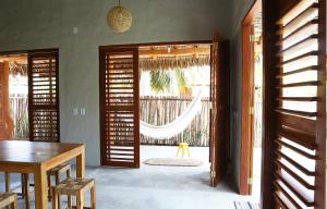ein Esszimmer mit einer Tür, die auf eine Terrasse führt in der Unterkunft Vila da Praia - Barra Grande, PI in Barra Grande