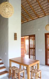 ein Esszimmer mit einem Holztisch und Stühlen in der Unterkunft Vila da Praia - Barra Grande, PI in Barra Grande
