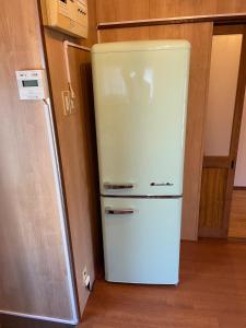 a white refrigerator freezer sitting in a kitchen at Shimanoyado Kon Bettei -En- - Vacation STAY 64087v in Oshima