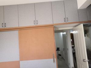 a kitchen with white cabinets and an open door at PSR Cosmos in Sarjāpur