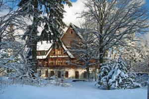 ein großes Haus ist mit Schnee bedeckt in der Unterkunft Berghotel Friedrichshöhe in Kurort Altenberg