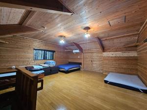 una camera con due letti in una cabina con pareti in legno di Ryukyo no Sato Auto Campsite - Vacation STAY 25331v a Torisu
