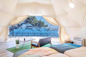 a bedroom with a bed and a view of the ocean at La-gum - Vacation STAY 42361v in Inatori