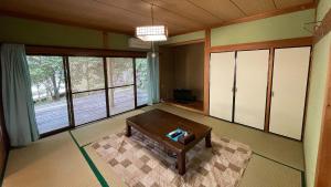 a living room with a table and some windows at Shimanto Yamamizuki - Vacation STAY 36943v in Shimanto