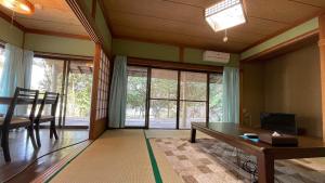 a living room with a table and a sliding glass door at Shimanto Yamamizuki - Vacation STAY 36943v in Shimanto
