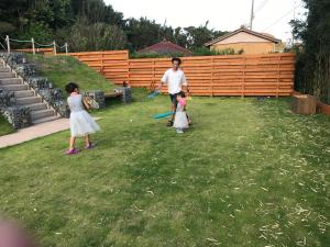a man and two children playing baseball in a yard at FARMER'S FIELDZ - Vacation STAY 42161v in Hongō