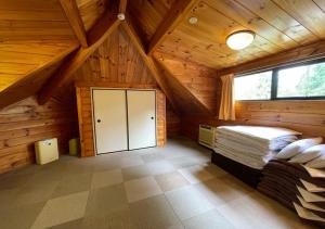 a bedroom in a log cabin with a bed and a window at NAKADAKI ART VILLAGE - Vacation STAY 41950v in Shiigi