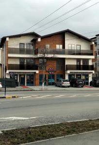 un edificio su una strada con auto parcheggiate di fronte di Eroilor Apartments a Curtea de Argeş