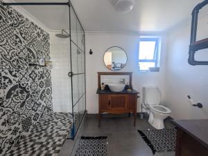 a bathroom with a shower and a sink and a toilet at Walmer Haven - Cosy Retreat in Gqeberha +67 photos