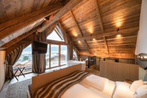 a bedroom with a large bed in a room with wooden ceilings at Baumhaus by Hotel Gassner in Neukirchen am Großvenediger