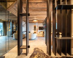 a living room with wooden ceilings and glass walls at Baumhaus by Hotel Gassner in Neukirchen am Großvenediger