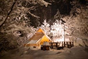 une tente dans une forêt enneigée la nuit dans l'établissement Shirasu-Ojiro FLORA Campsite in the Natural Garden - Vacation STAY 00655v, à Shirasu