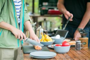 two people in a kitchen preparing food on a table at Shirasu-Ojiro FLORA Campsite in the Natural Garden - Vacation STAY 00652v in Shirasu