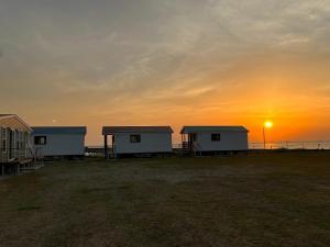 a group of houses on the beach at sunset at Kisarazu CAMP ORGANIC FIELD in Mitate- Vacation STAY 42113v in Sakadoichiba