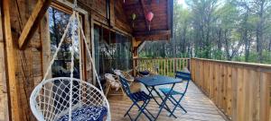a porch with a table and chairs on a deck at Le Masdemoiselle Chalet in Salernes